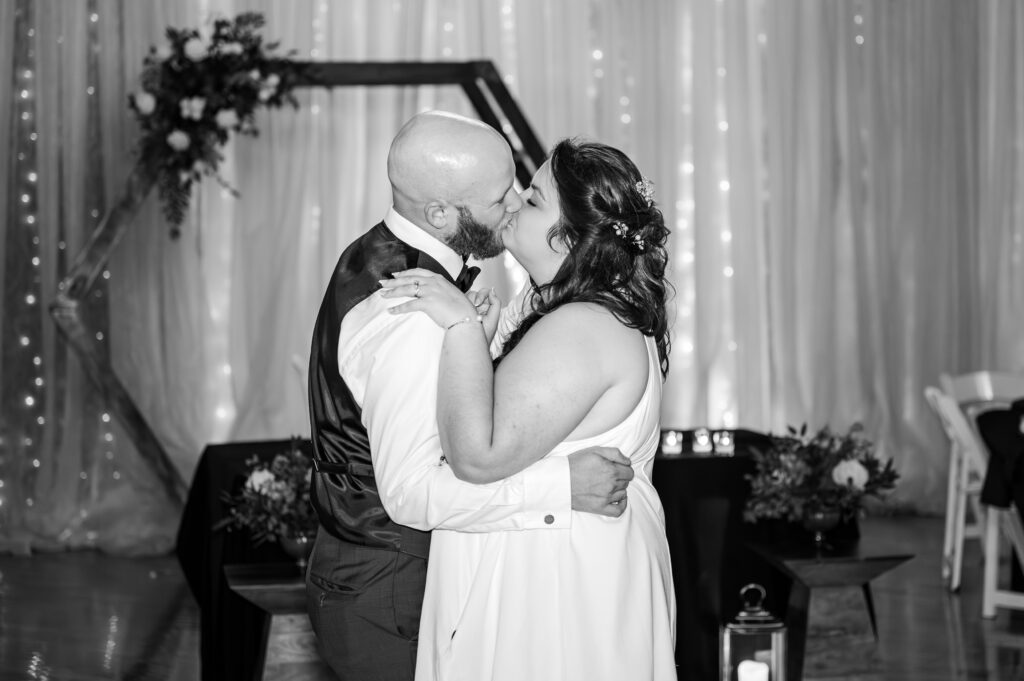 Bride and groom sharing first kiss at indoor lexington wedding venue