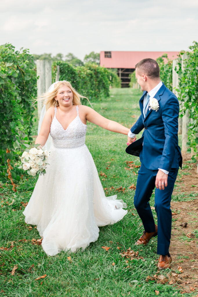 bride and groom running in vineyard at lexington wedding