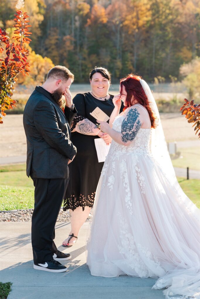 bride crying during lexington wedding ceremony vows with stunning fall backdrop